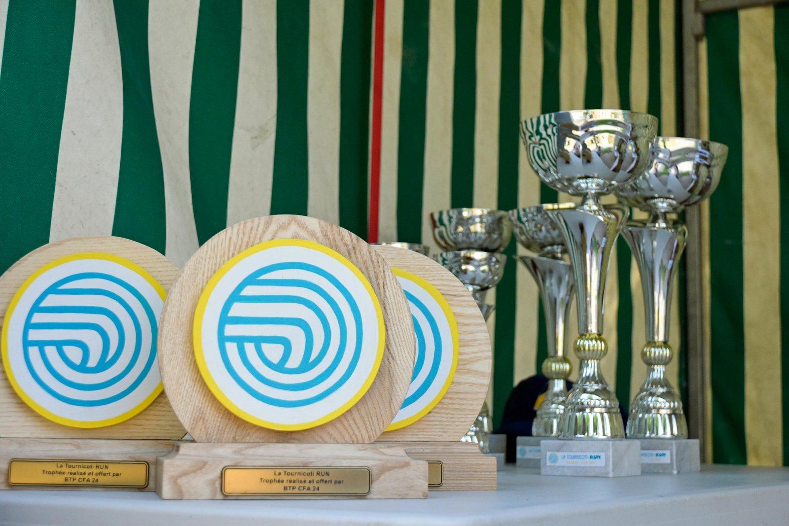 Les trophées en bois aux couleurs de la course, alignés à côté des coupes