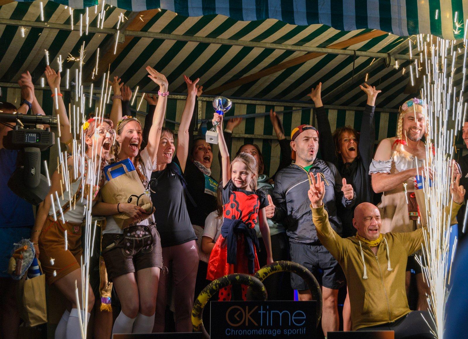 Les vainqueurs brandissent leur coupe sur le podium, sous les gerbes d'étincelles