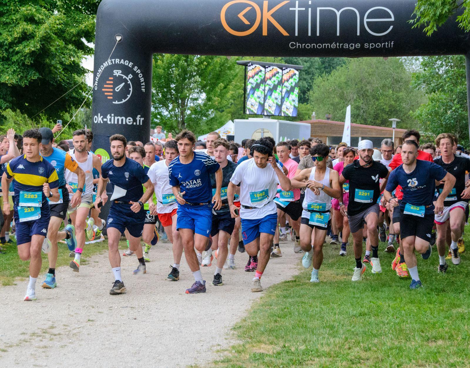 Le peloton du relais s'élance dans la nuit, éclairé par l'arche de départ